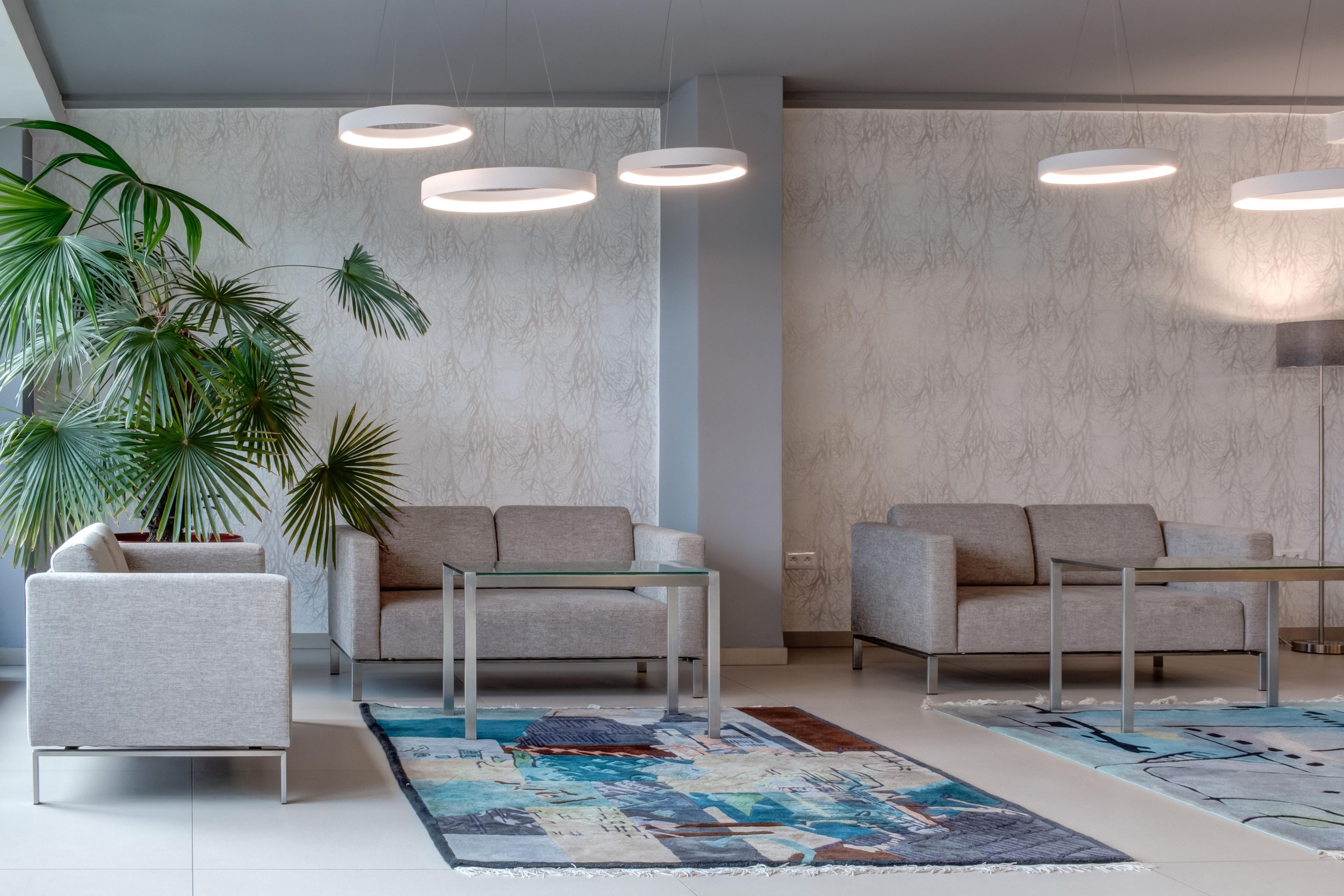 Un salon moderne avec deux canapés, une table basse et une grande plante en pot.