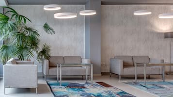 Un salon moderne avec deux canapés, une table basse et une grande plante en pot.