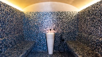 Bathroom features a mosaic tile design and a central sink with a simple design.