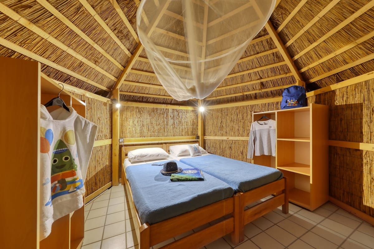 A room with a bed, a wardrobe, and a hanging garment rack.