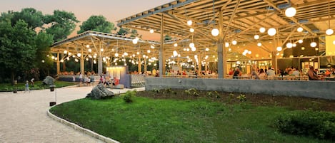 An outdoor pavilion with a covered seating area and a stone pathway.