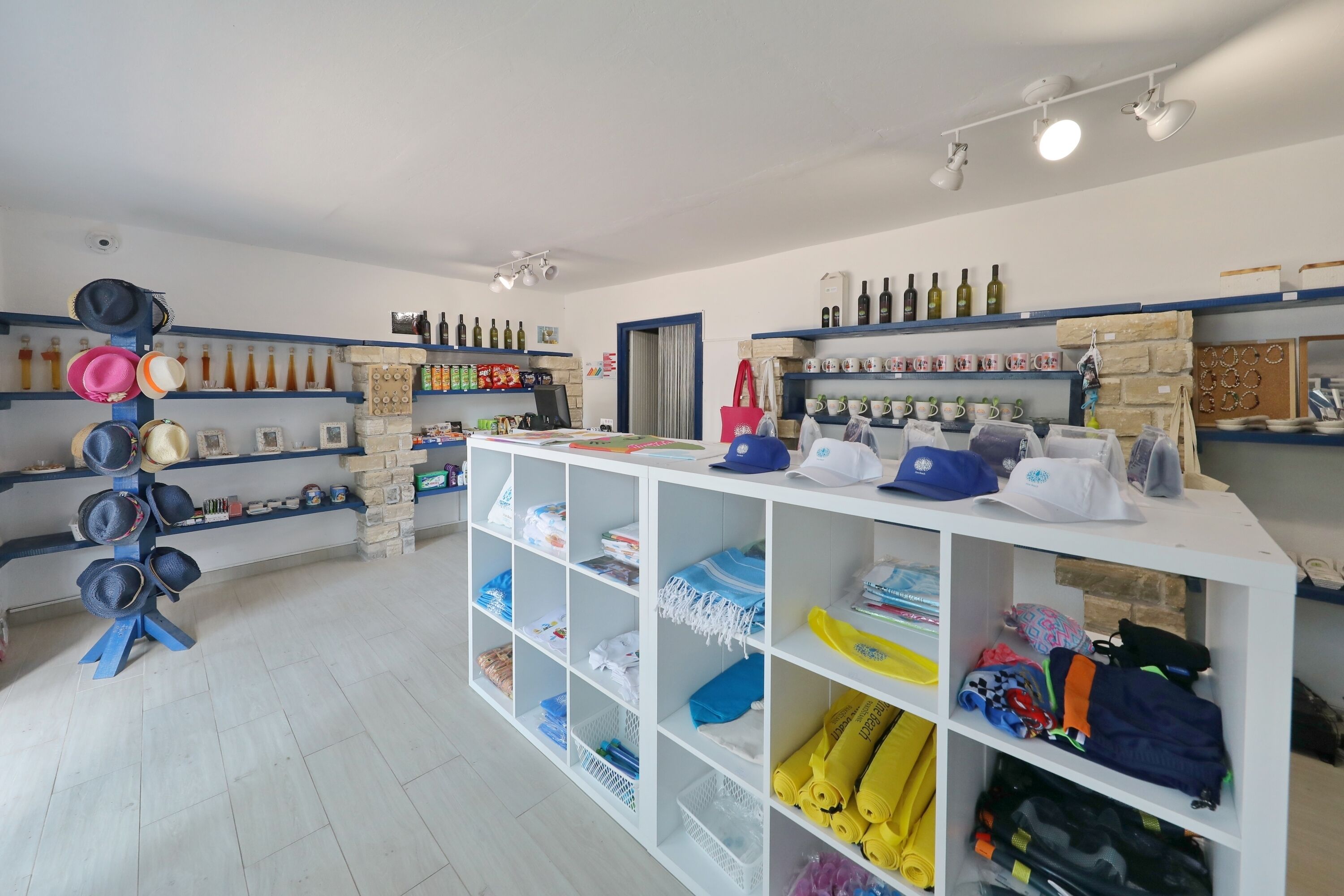 Un magasin bien organisé, avec des étagères remplies de chapeaux, de bouteilles et de divers autres articles.