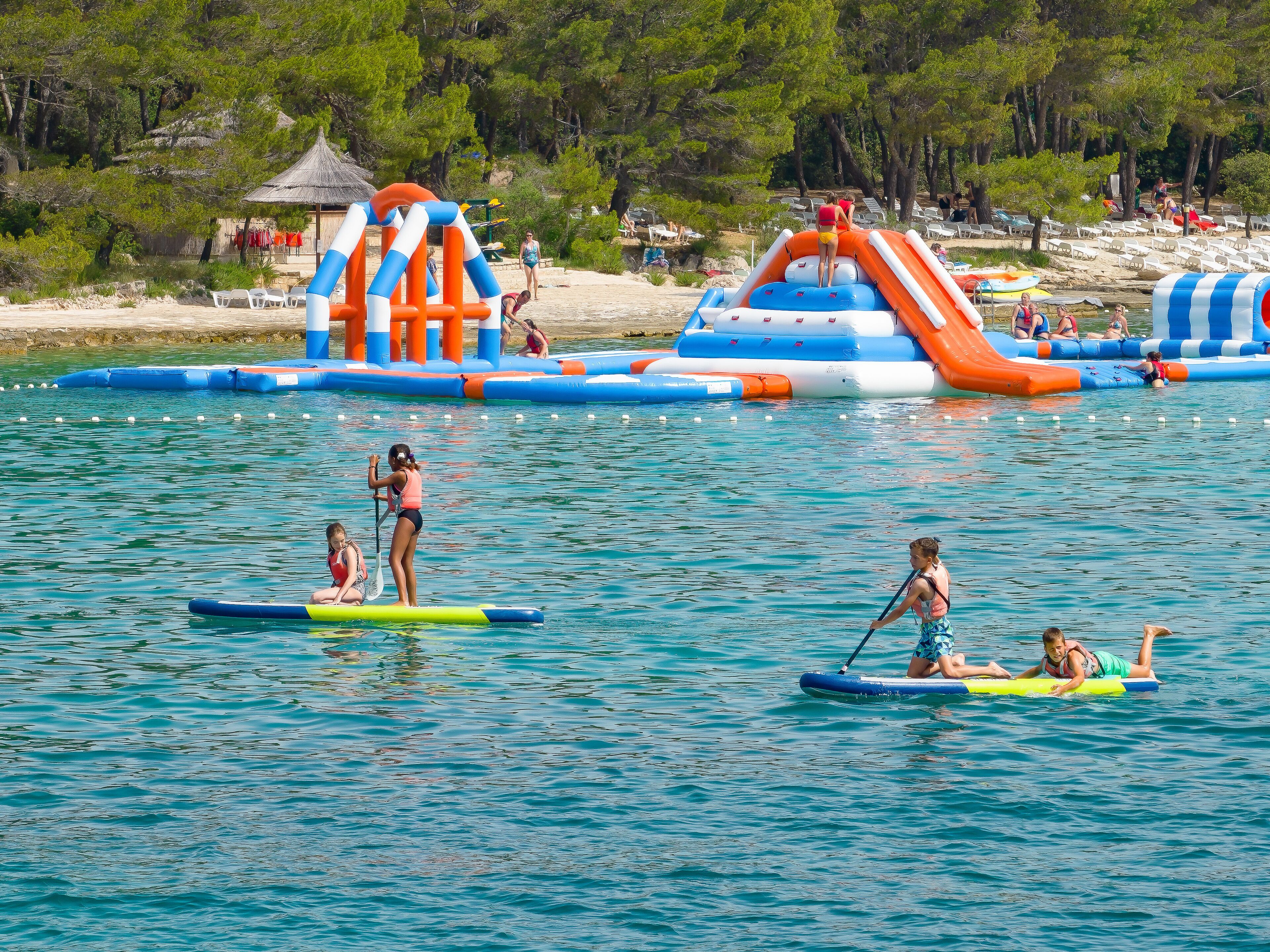 A water park with inflatable play structures and paddleboards.