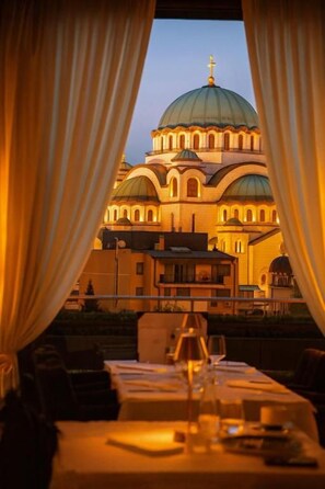 A dining table with a view of a building with domed architecture.