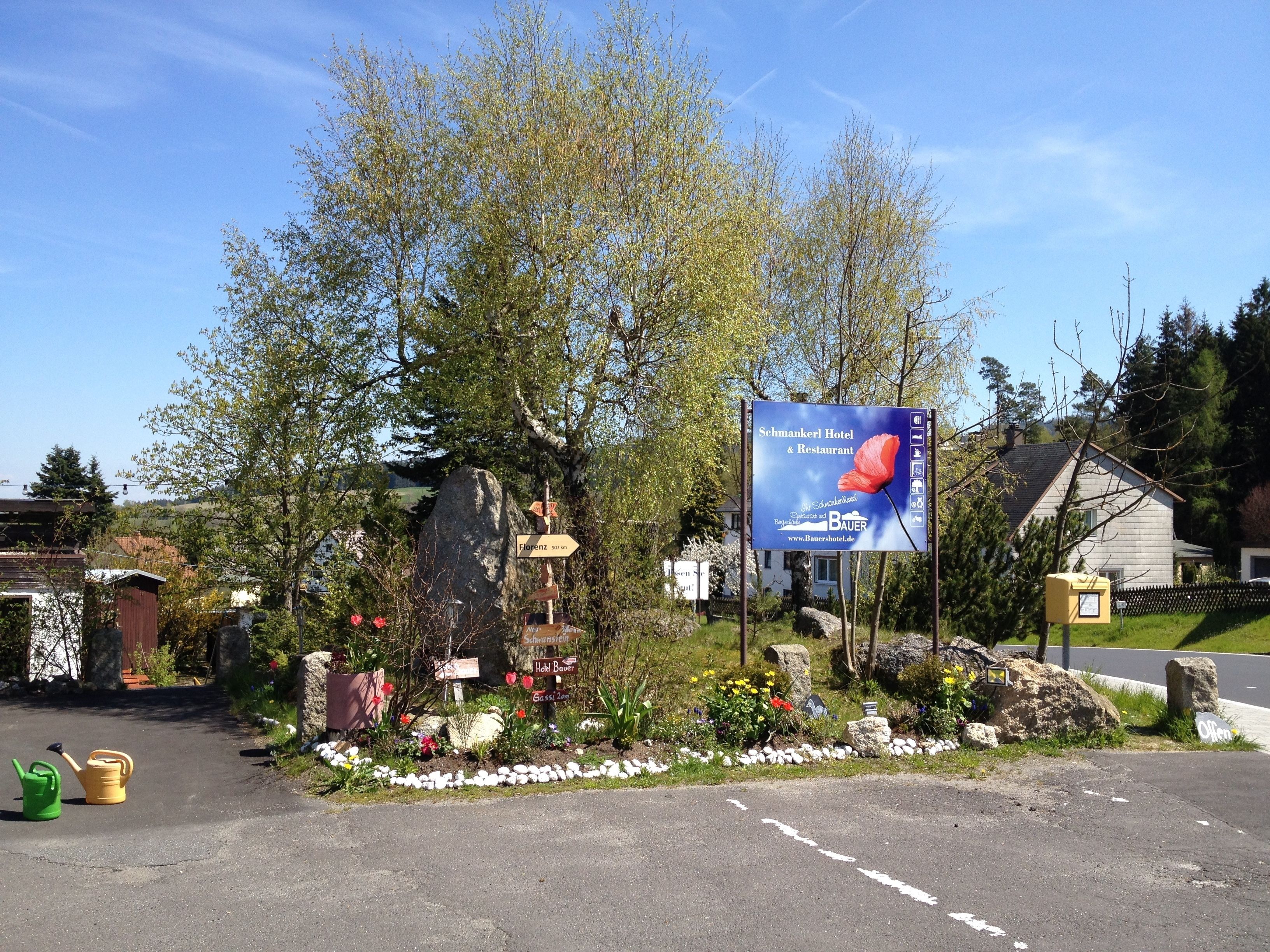 Un panneau indicateur au bord de la route pour l’hôtel-restaurant Schmanker, avec des panneaux directionnels indiquant la direction de Florence et de l’hôtel Bauer.