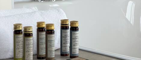 Une salle de bain avec une baignoire, un miroir et plusieurs bouteilles de shampoing et de lotion.