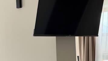 Una camera d'albergo moderna con una TV a schermo piatto montata a parete, un termostato e un interruttore della luce.