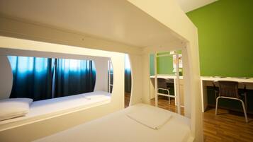 A compact room with a bunk bed, a desk, and a chair.