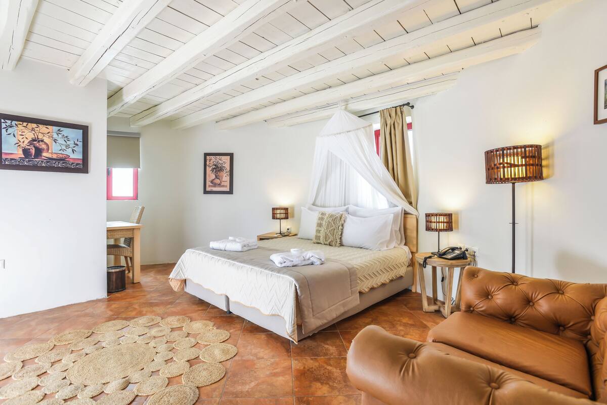 A bedroom with a bed, bedside tables, a chair, and a floor rug.