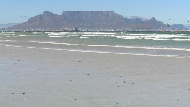 A beach with a prominent mountain in the background. - Small Bay Guest House (Cape Town)