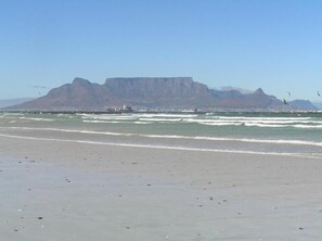 A beach with a prominent mountain in the background. - Small Bay Guest House (Cape Town)