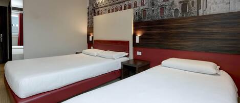 A hotel room with two beds, a red headboard, and a mural of a castle on the wall.