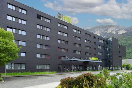 A modern hotel building with a flat roof, multiple windows, and a sign indicating it is a B&B hotel.