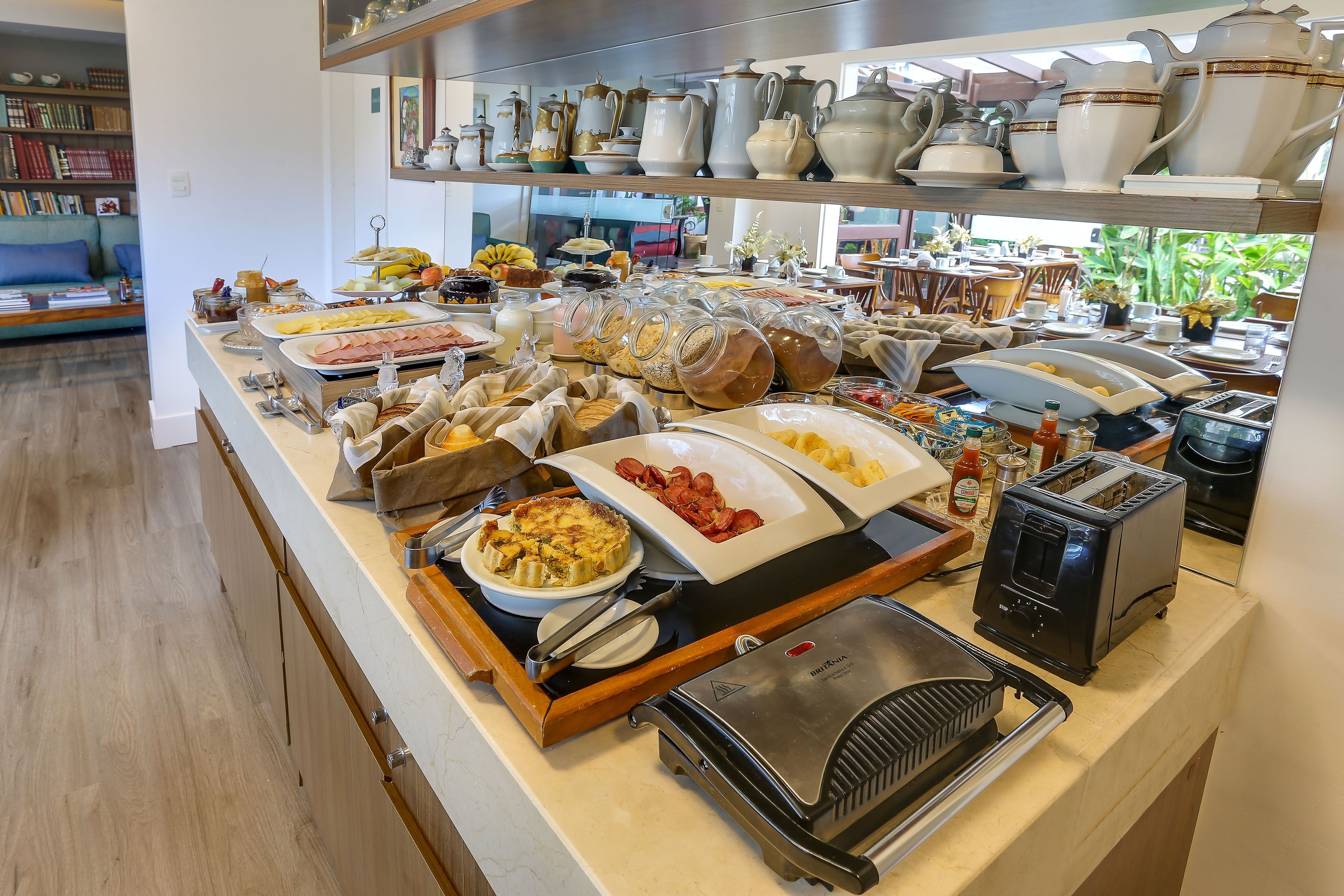 A buffet with various food items and kitchen appliances.
