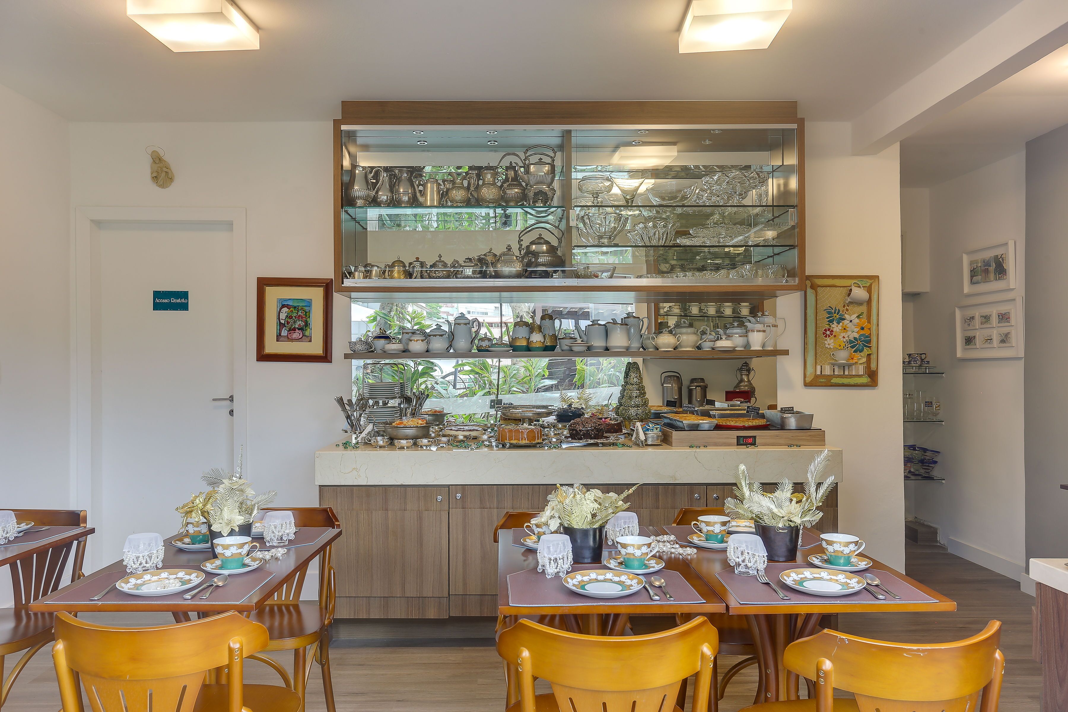 A dining area with wooden tables and chairs, a glass display case with kitchenware, and a door labeled "Entrance."
