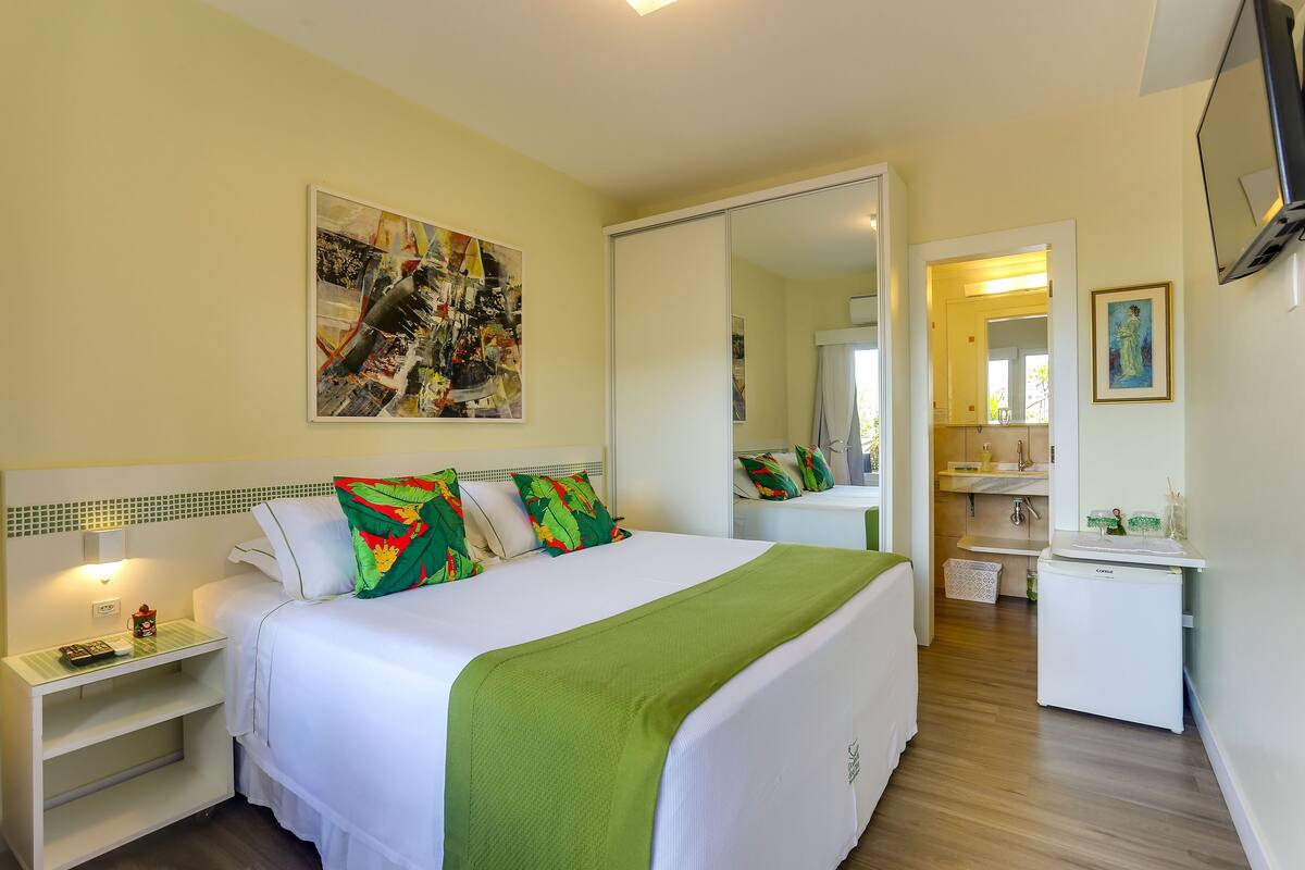 Ein Hotelzimmer mit Bett, Nachttisch und einer kleinen Küchenzeile.