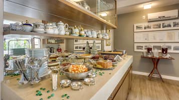 A buffet setup with various dishes and silverware.