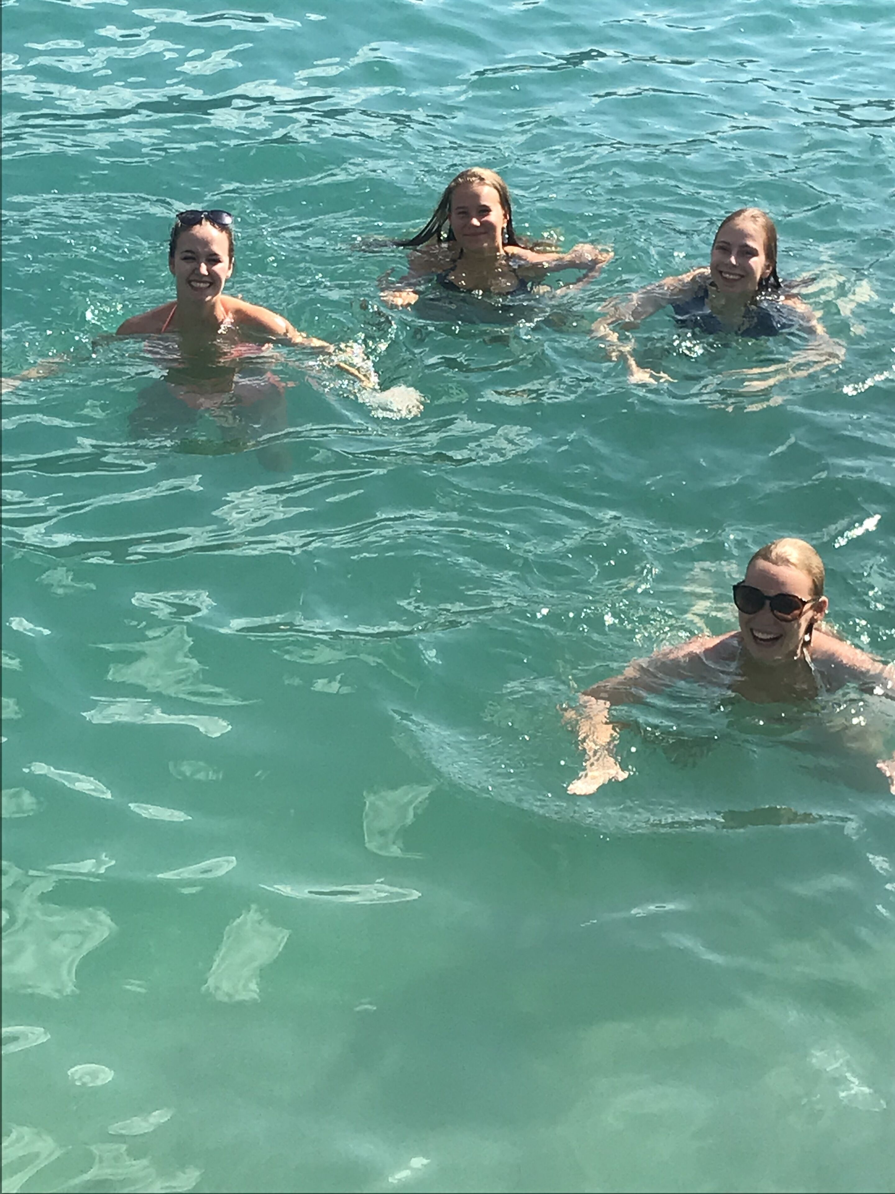 Eine Gruppe von Menschen schwimmt in klarem, blauem Wasser.