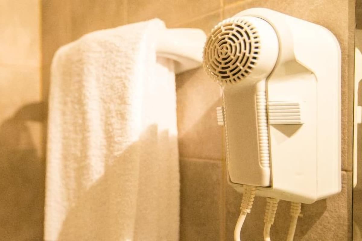 Ein an der Wand im Badezimmer befestigter Haartrockner.