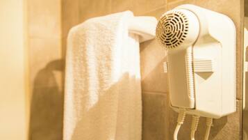 A hairdryer mounted on a wall in a bathroom.