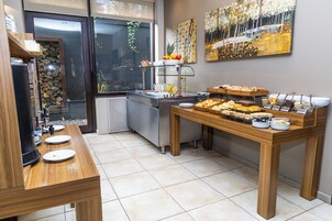 A breakfast buffet with various food items and a coffee station.