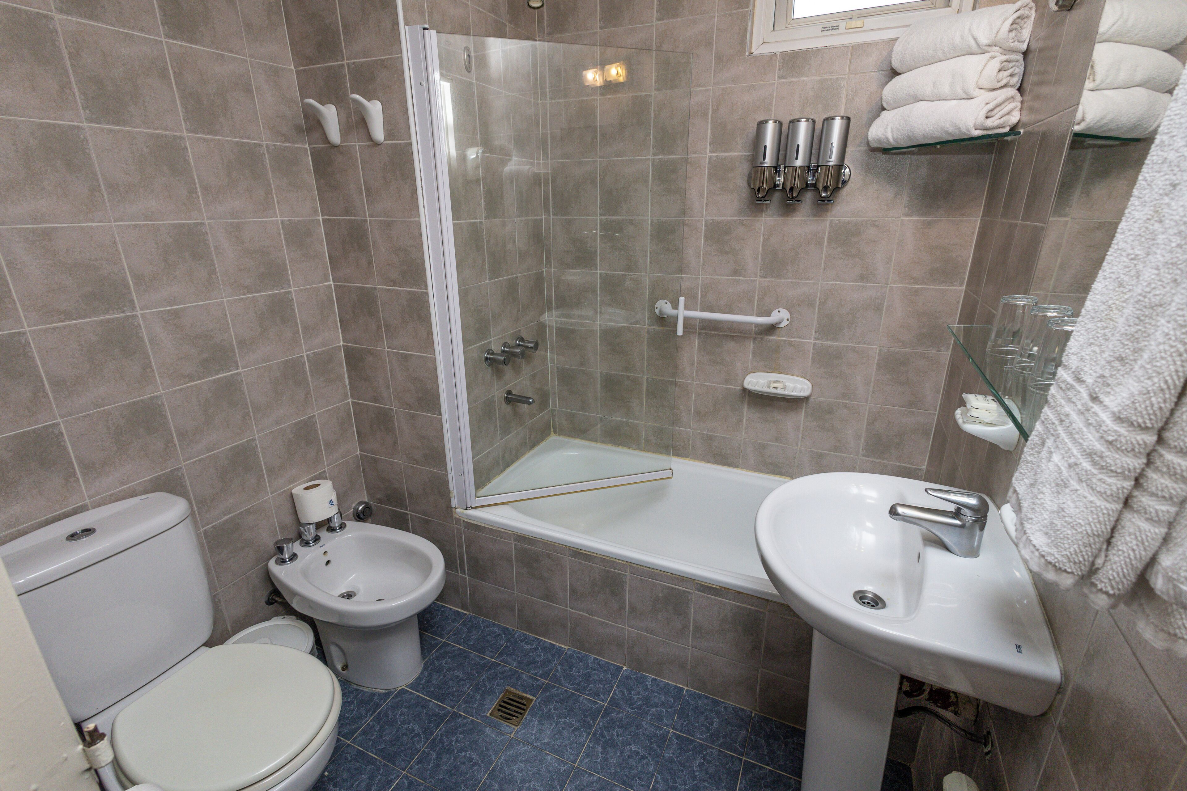 Ein Badezimmer mit Toilette, Bidet, Dusche und Waschbecken.
