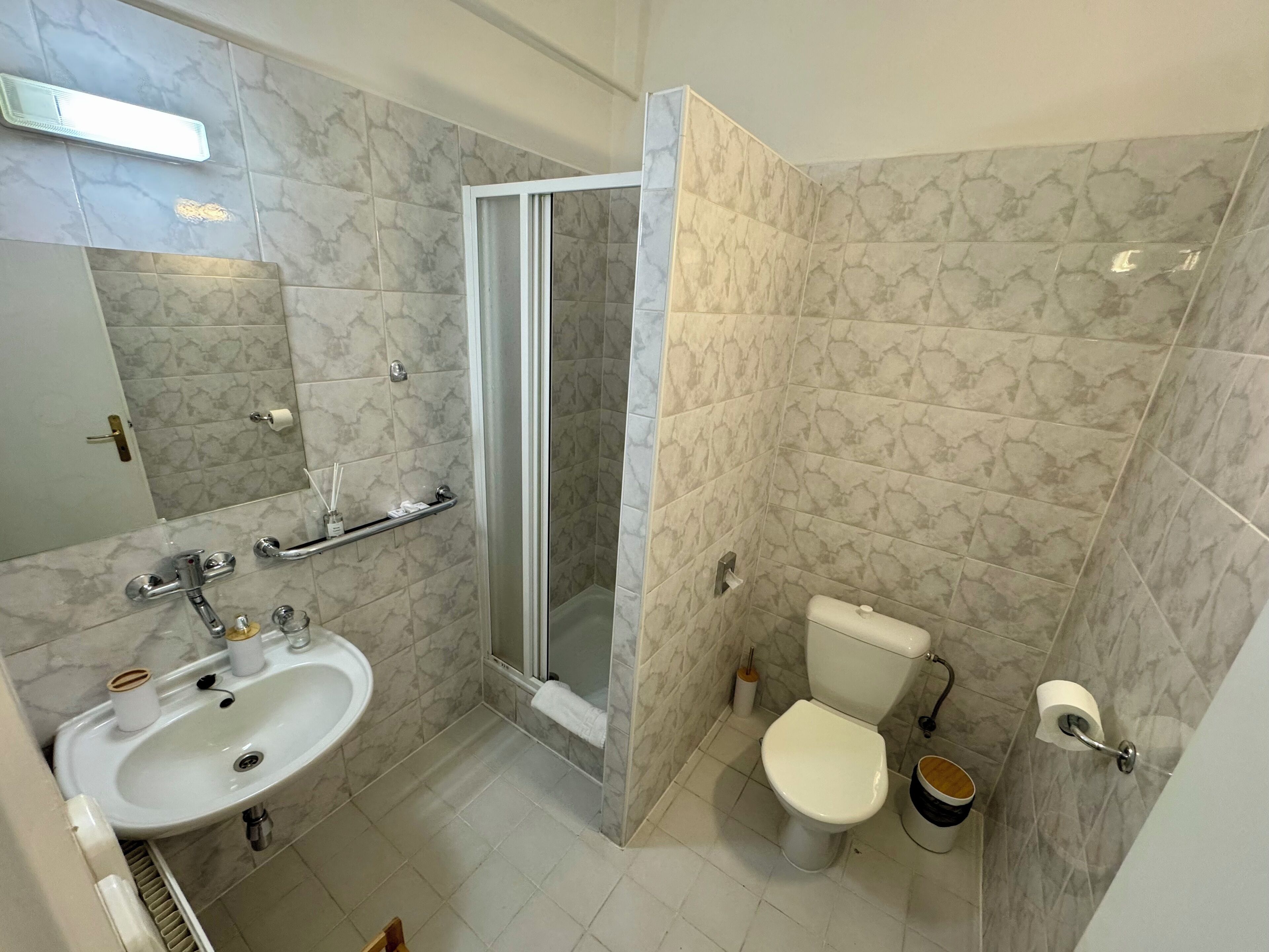 Un baño con lavamanos, inodoro y ducha.