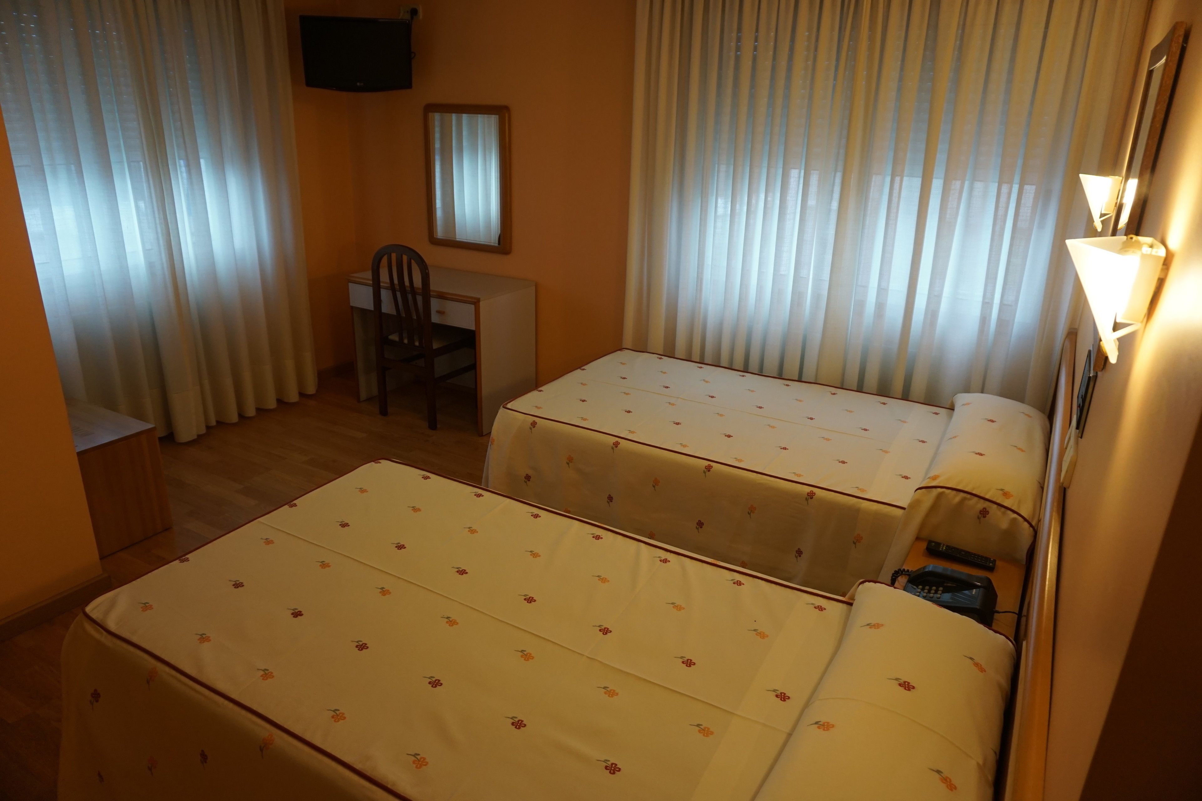 A room with two beds, a desk, and a chair.
