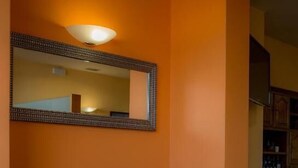 A corner seating area with a dark blue sofa and a large mirror with a patterned frame. - Europa (Arteixo)