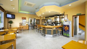 A restaurant with a bar area, multiple seating options, and a television screen. - Europa (Arteixo)