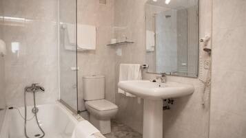 A modern bathroom with a glass-enclosed shower, a toilet, and a pedestal sink.