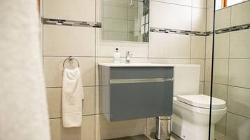 A modern bathroom with a toilet, sink, and towel rack.