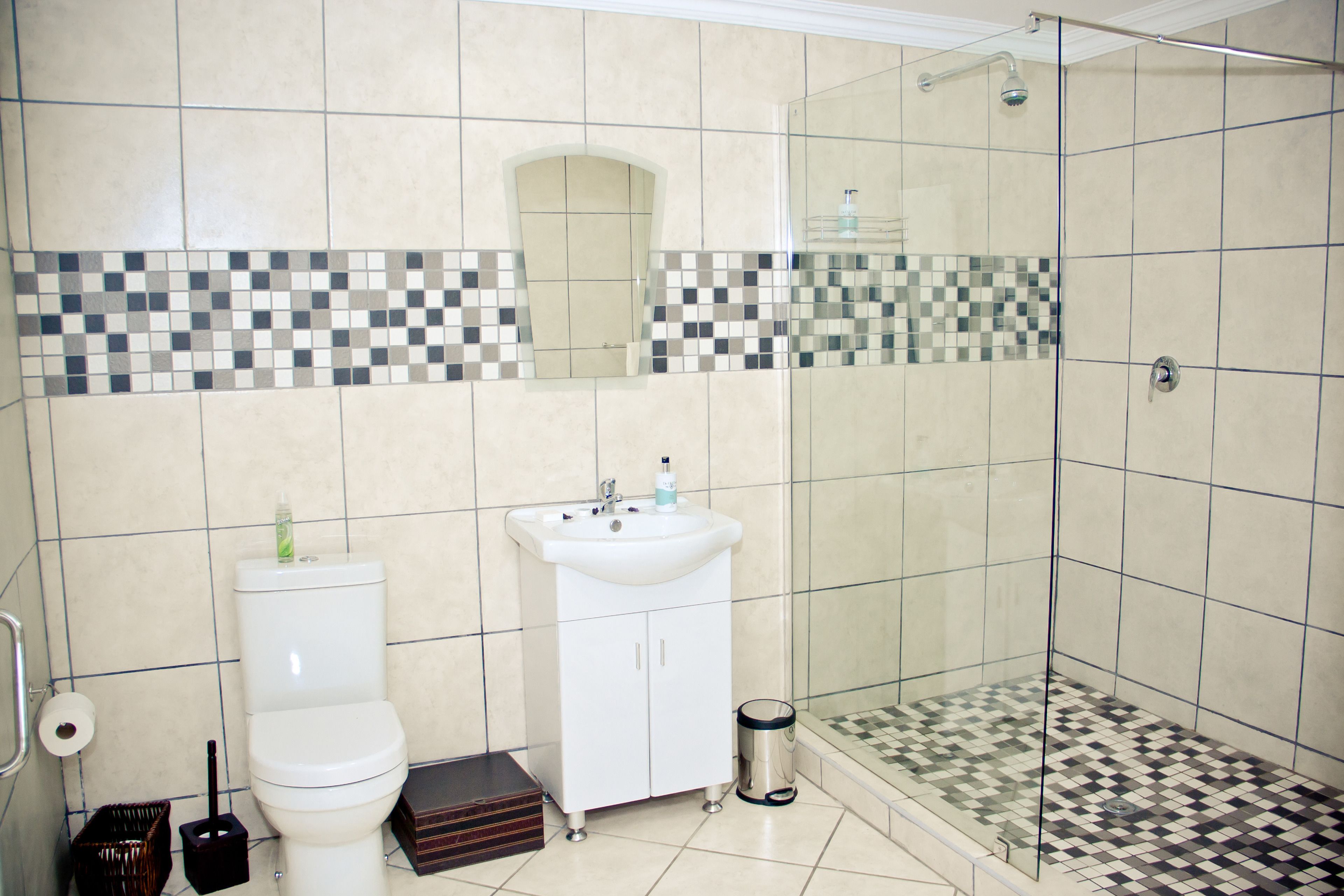 Une salle de bain comprenant des toilettes, un lavabo et un espace douche.