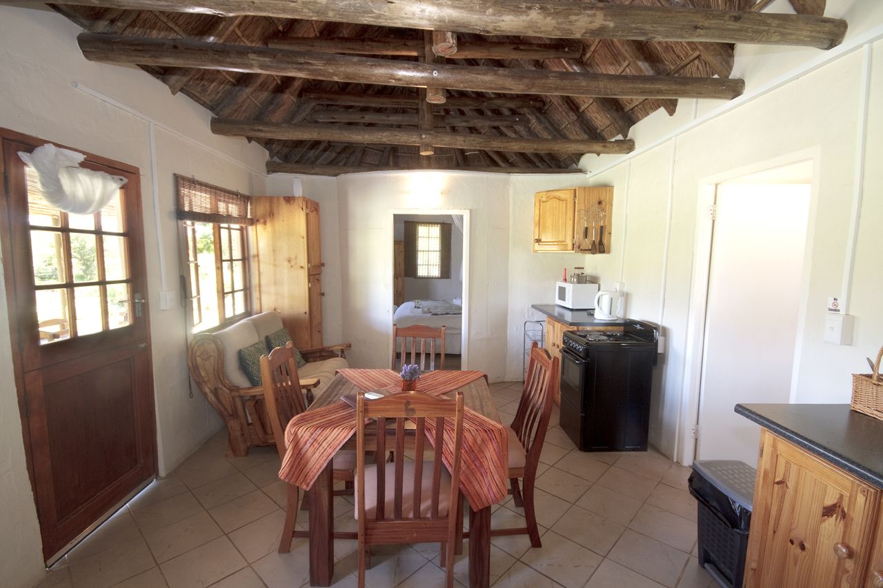 Una cocina rústica con muebles de madera, una mesa de comedor y un espacio para preparar alimentos.