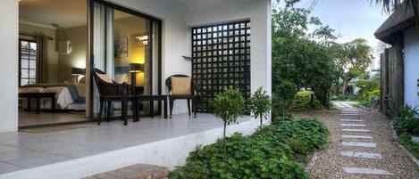 A modern house with a patio area featuring a seating arrangement and a small garden.