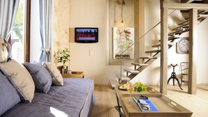 Una sala de estar moderna con sofá, mesa de centro y una escalera.