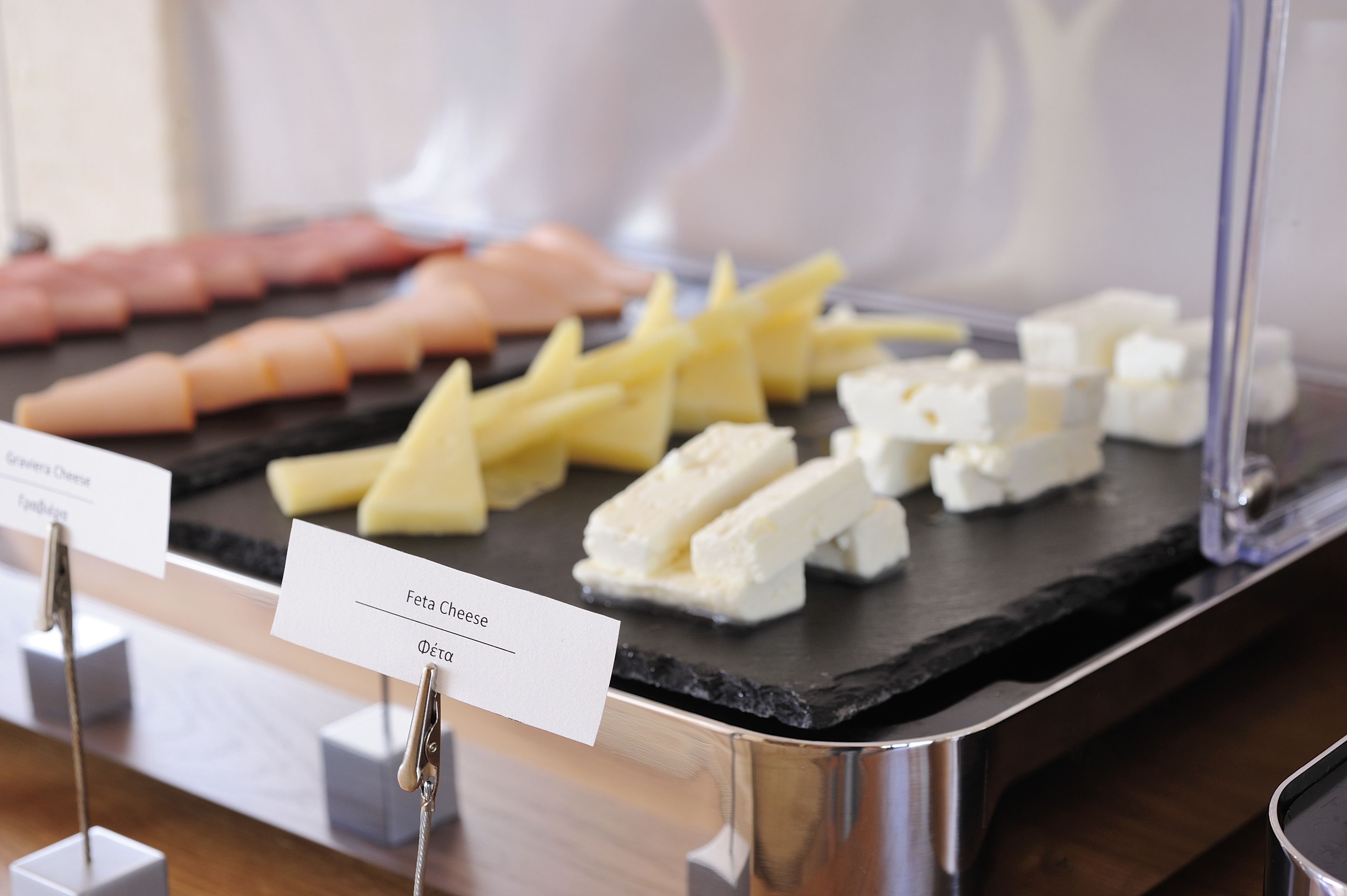 A cheese board with feta cheese and other cheeses.