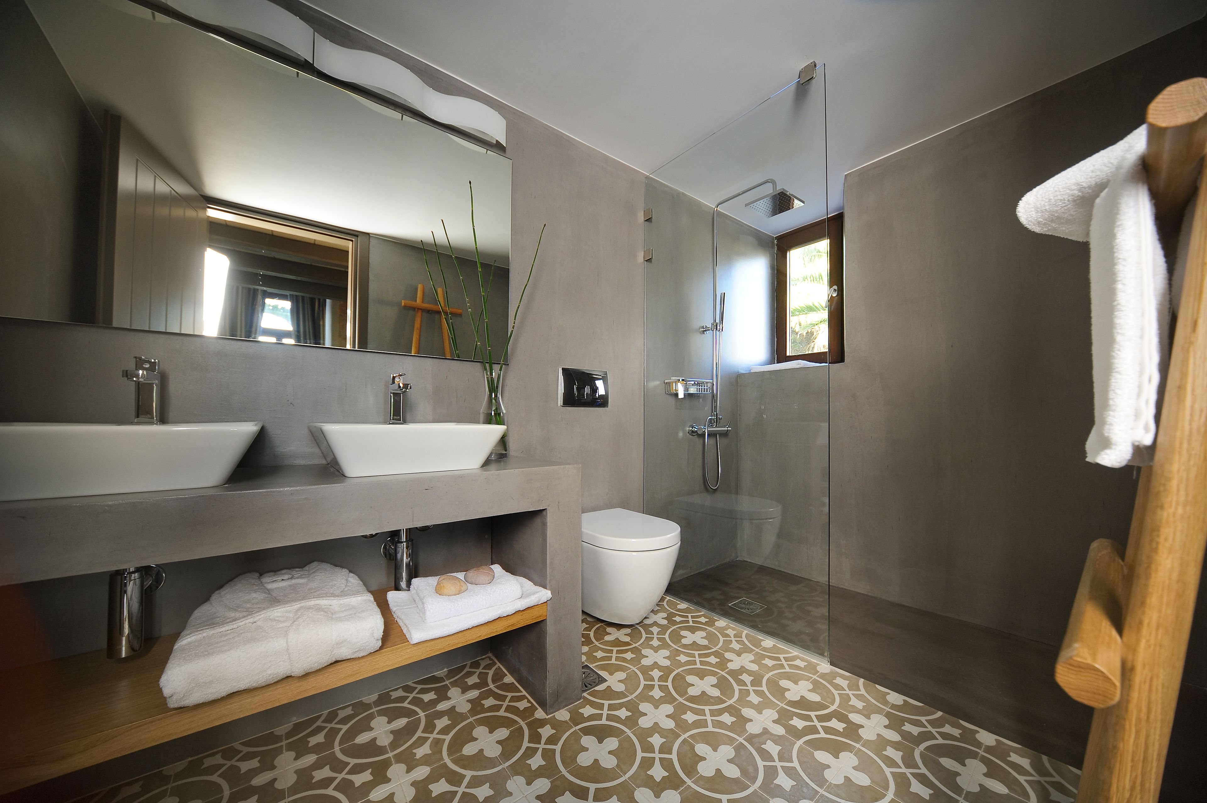 A modern bathroom with two sinks, a toilet, and a shower.