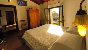 Un dormitorio con cama, armario de madera y televisor en la pared.