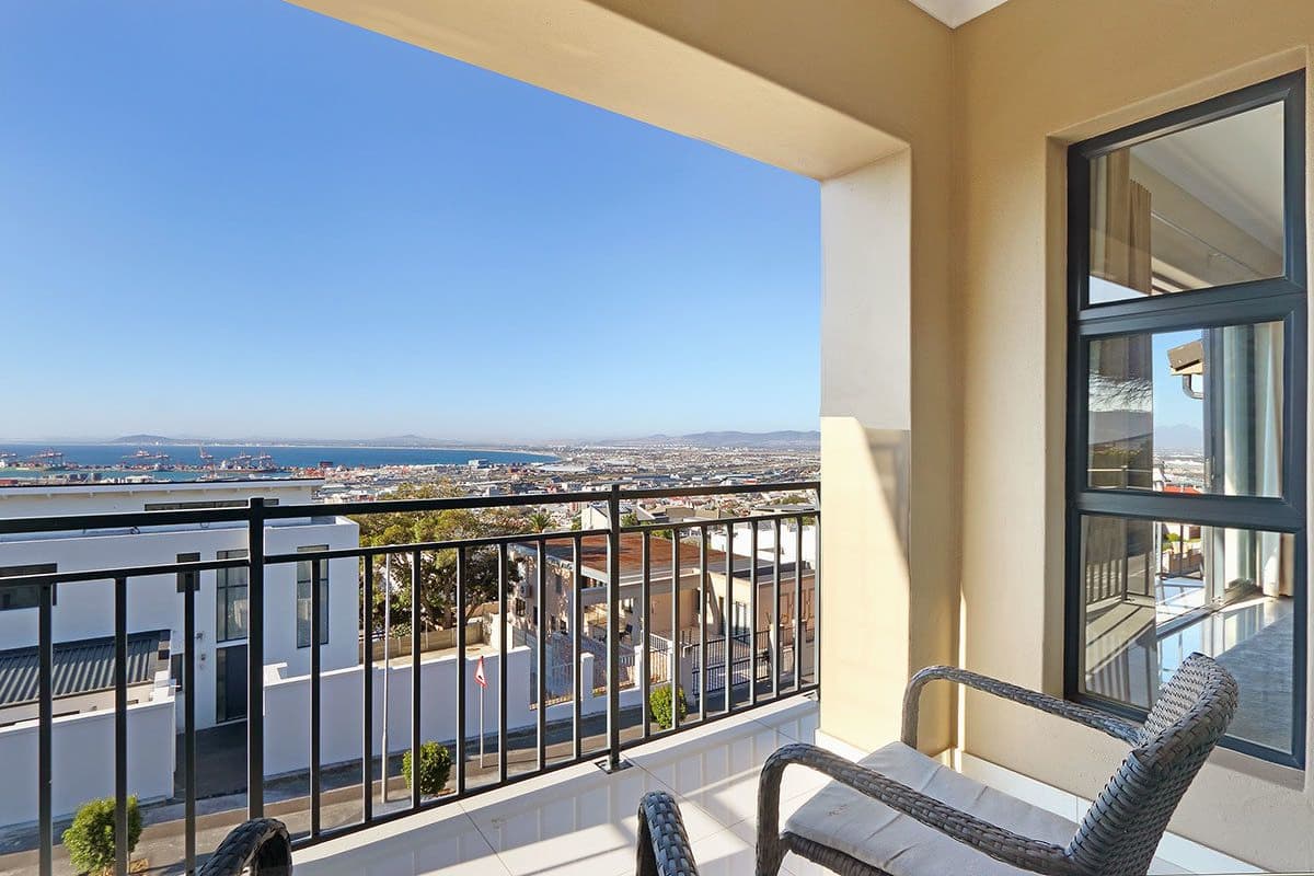 A balcony with a view of a cityscape and a body of water.