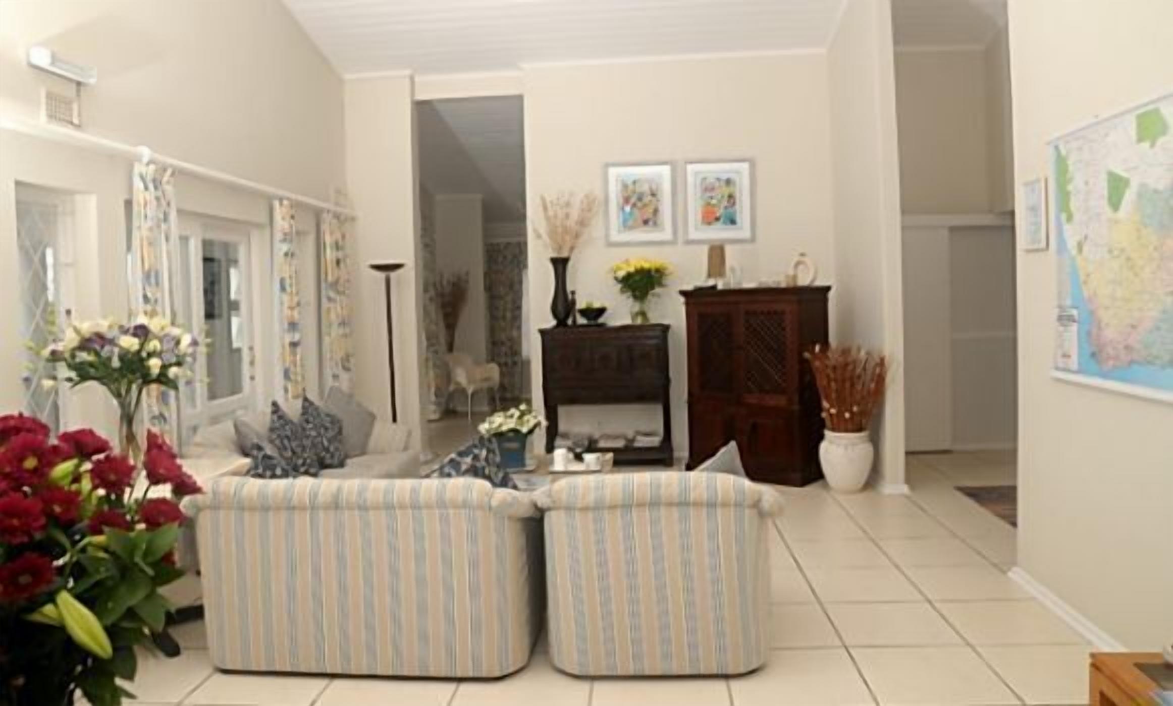 A living room with a sofa set, a coffee table, and a cabinet. There are two framed pictures on the wall.