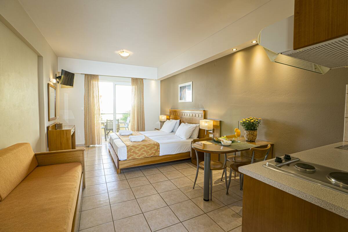 Une chambre d’hôtel comprenant un lit, un canapé, une table à manger et une kitchenette.
