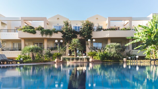 Ein Hotel mit Pool, Außenbereich und üppiger Bepflanzung.