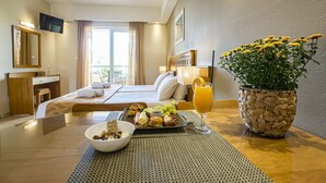 Ein Hotelzimmer mit Bett, Nachttisch, Frühstückswagen und einer Topfpflanze.