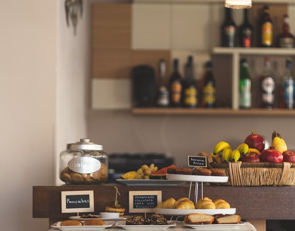 A breakfast buffet with labeled sections for pancakes, homemade chocolate cake, and banana bread.