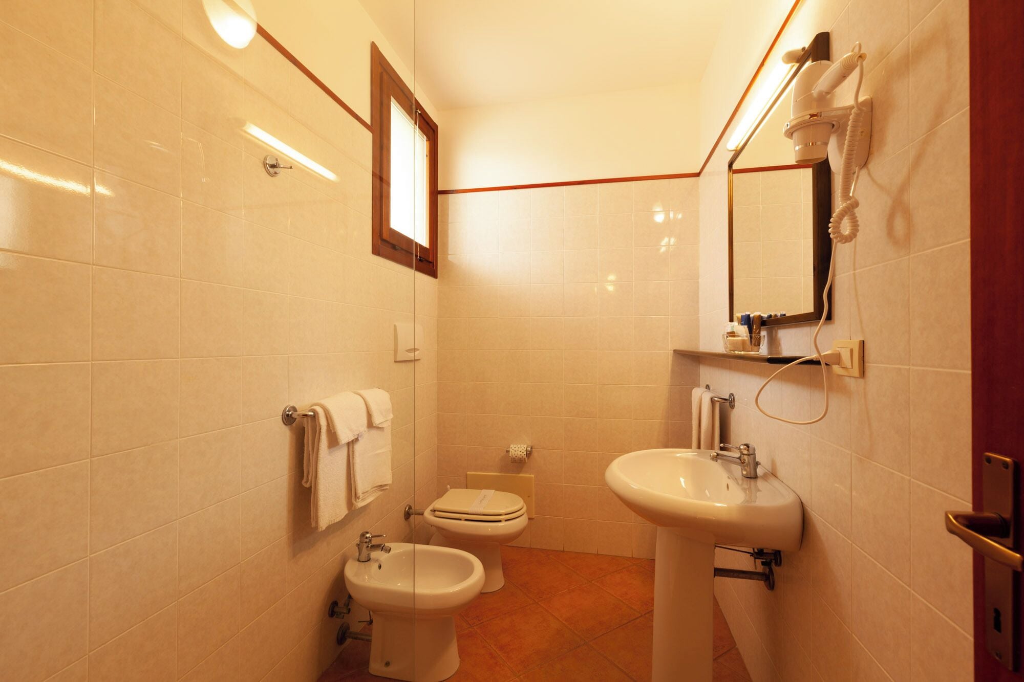 A small bathroom with a toilet, bidet, and sink.