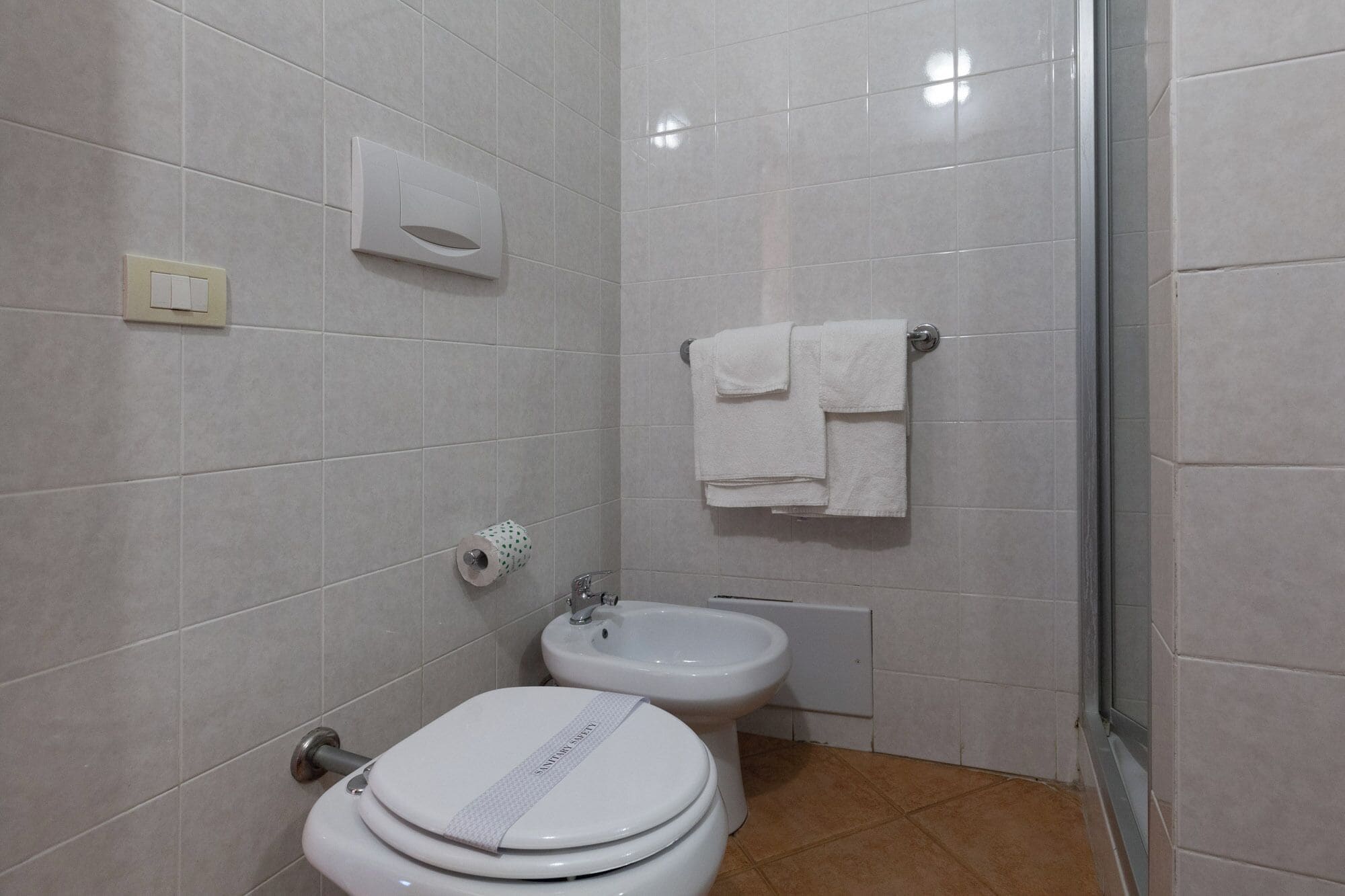 A bathroom with a toilet, bidet, and towel rack.