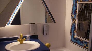 A bathroom with a sink, mirror, and bathtub.