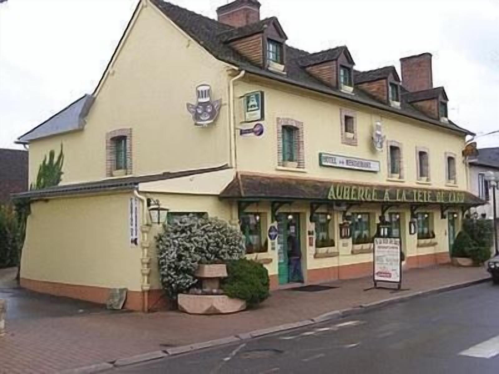 Un bâtiment sur lequel on peut lire l’inscription : « AUBERGE À LA TIÈRE ROUGE ».