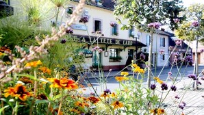 Un restaurant appelé « LA TE TE DE LARD », avec une façade traditionnelle et une vue sur la rue en premier plan.